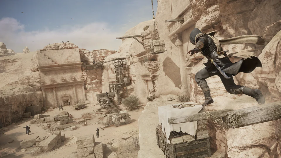 Basim leaps between wooden beams high above a desert excavation, robes trailing