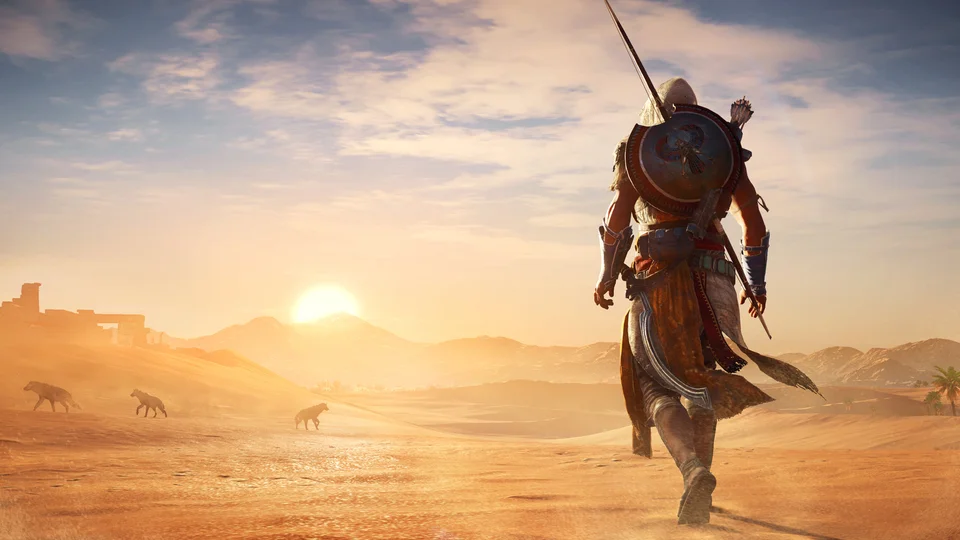 Bayek walks into the desert at sunset, shield and bow across his back, hyenas prowling the dunes behind him